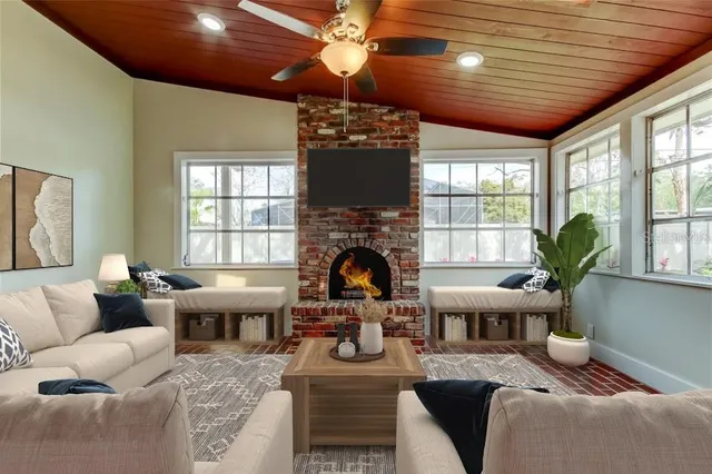 a living room with furniture a fireplace and a chandelier
