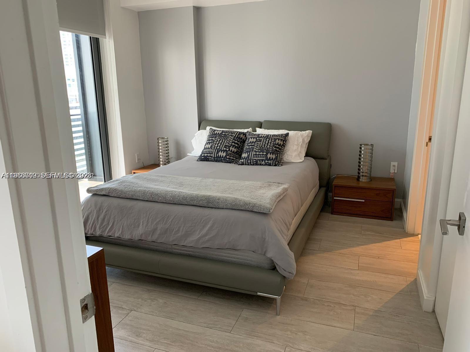 55 Southwest 9th Street, Unit 2307 Miami, FL 33130 - Photo 12 of 35 a bedroom with a bed and wooden floor