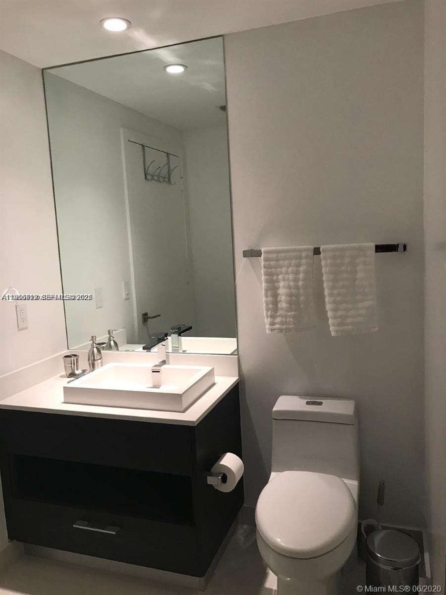 55 Southwest 9th Street, Unit 2307 Miami, FL 33130 - Photo 15 of 35 a bathroom with a toilet sink and mirror