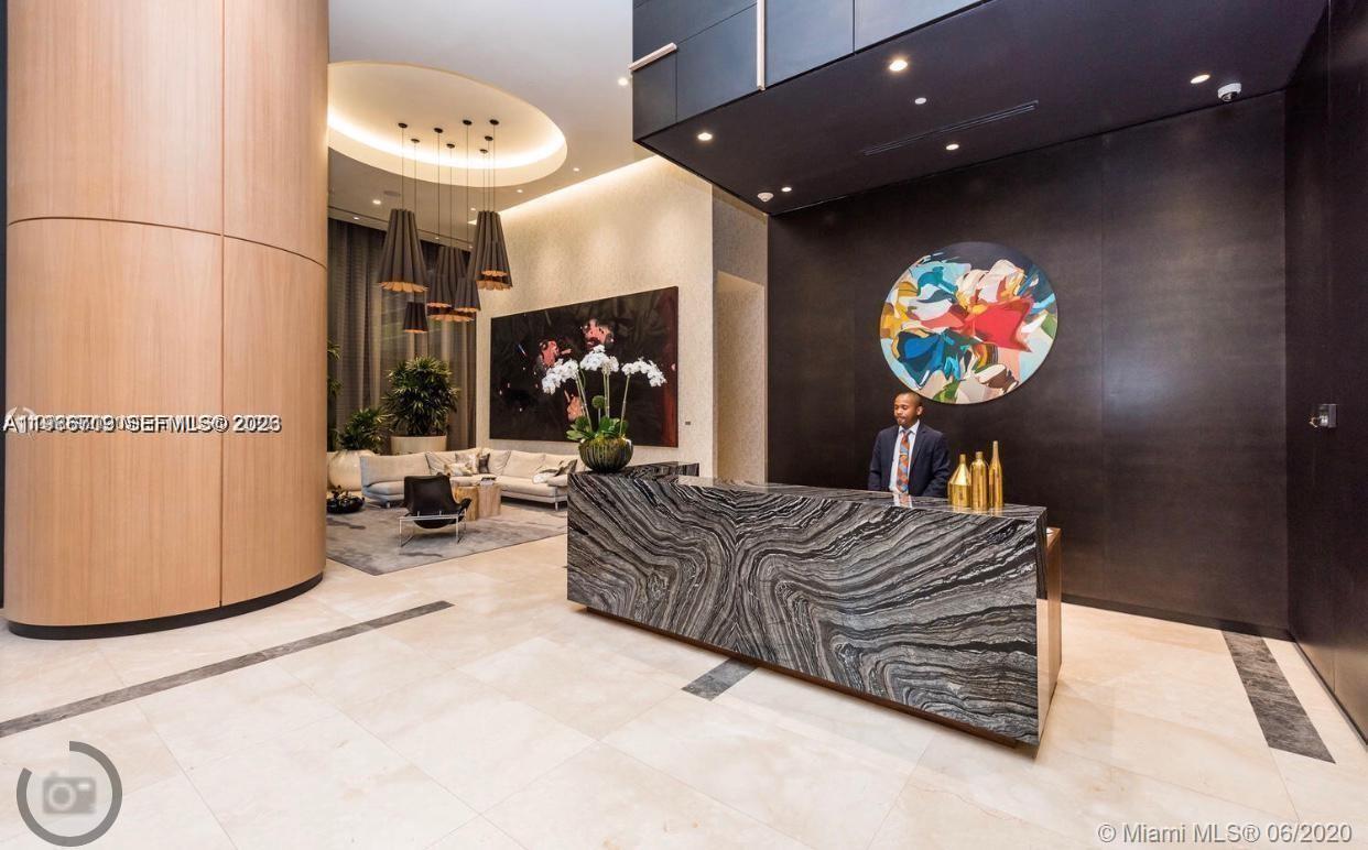 55 Southwest 9th Street, Unit 2307 Miami, FL 33130 - Photo 2 of 35 a living room with furniture a flat screen tv and a wall painting