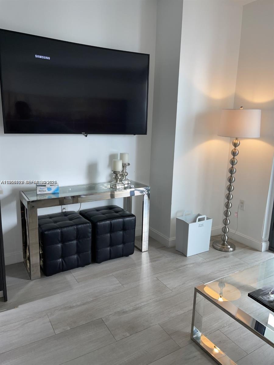 55 Southwest 9th Street, Unit 2307 Miami, FL 33130 - Photo 10 of 35 a living room with a couch and a flat screen tv