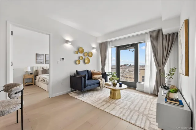 a living room with furniture a window and a potted plant