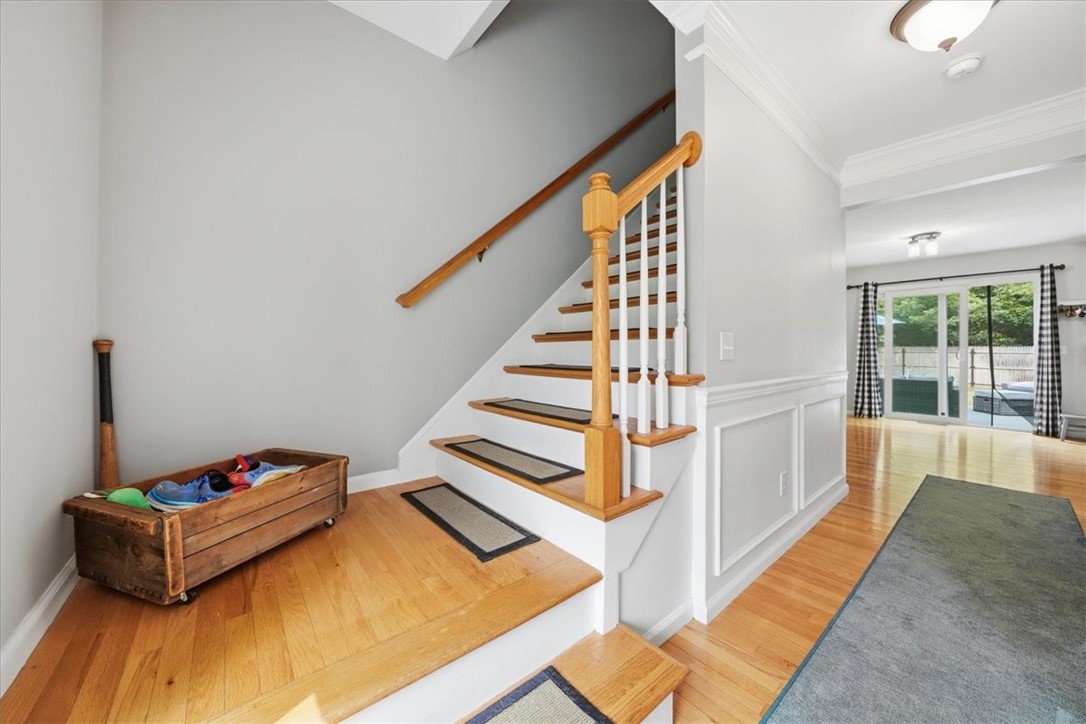 26 Davis Circle Warwick, RI 02886 - Photo 21 of 50 The grand two-story foyer sets the tone from the moment you enter, showcasing soaring ceilings, beautiful hardwood flooring, classic millwork, and an open staircase that enhances the home's bright, airy feel.