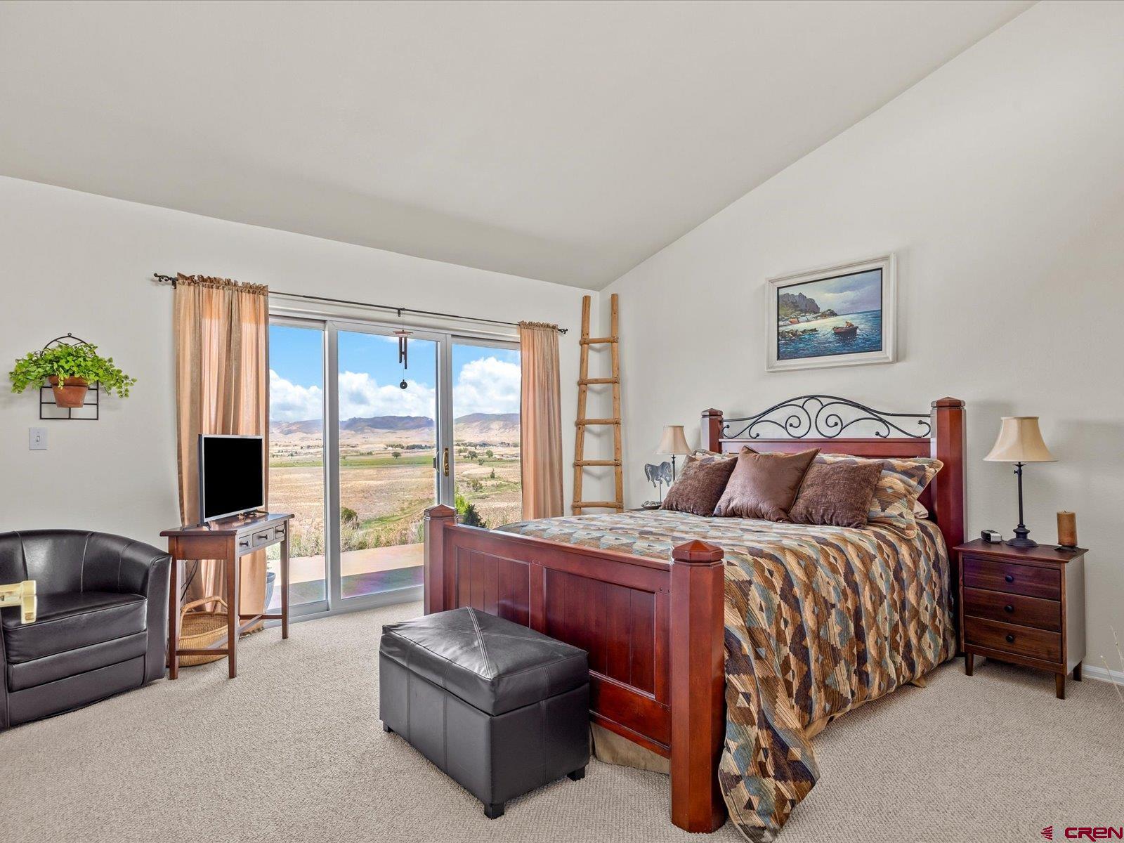 68149 Sunshine Road Montrose, CO 81401 - Photo 14 of 33 a bedroom with a bed couch and a large window