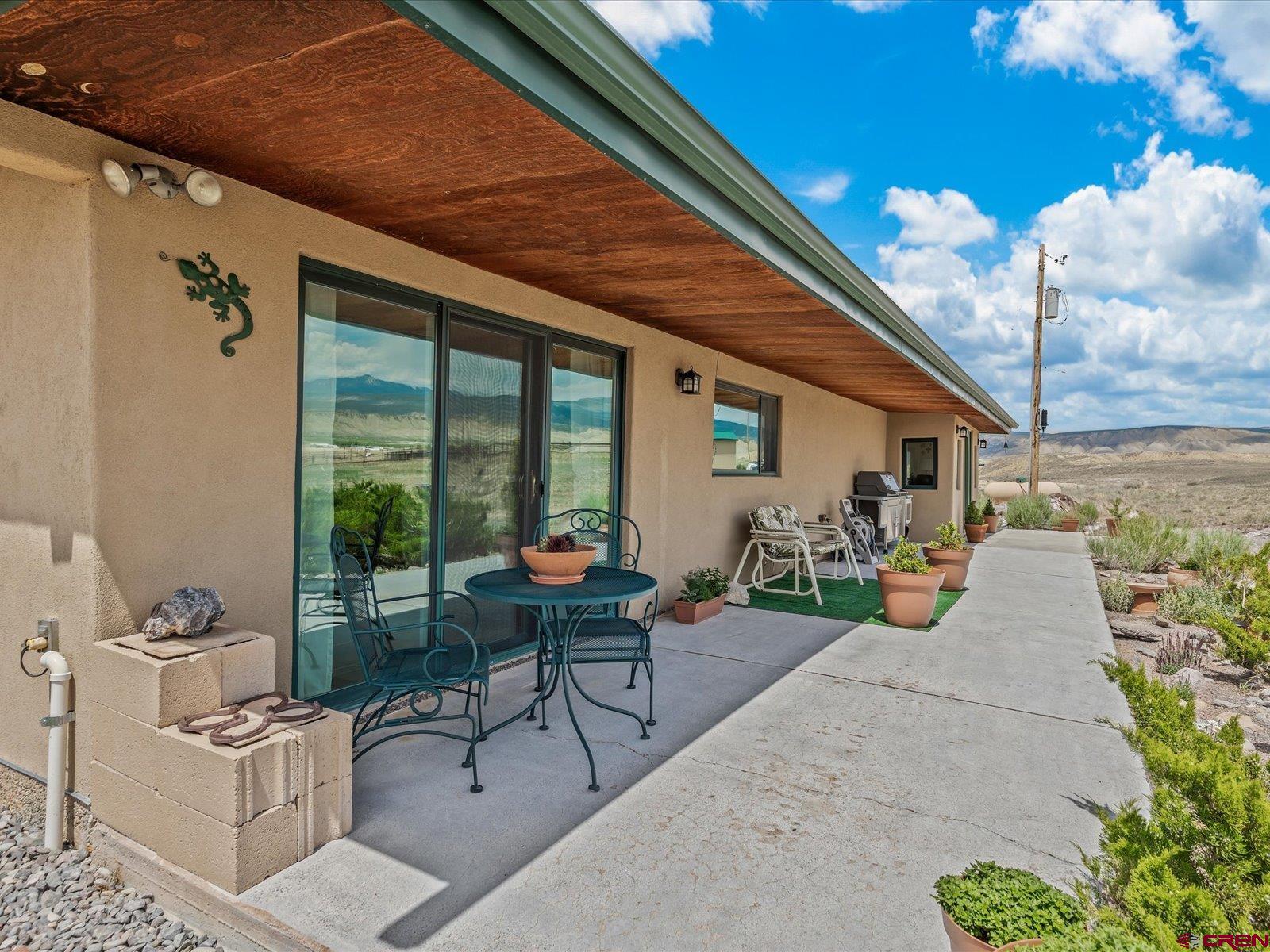68149 Sunshine Road Montrose, CO 81401 - Photo 21 of 33 a view of a patio with table and chairs potted plants with wooden floor