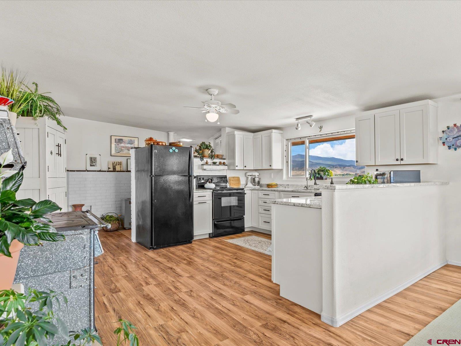 68149 Sunshine Road Montrose, CO 81401 - Photo 5 of 33 a kitchen with refrigerator and microwave