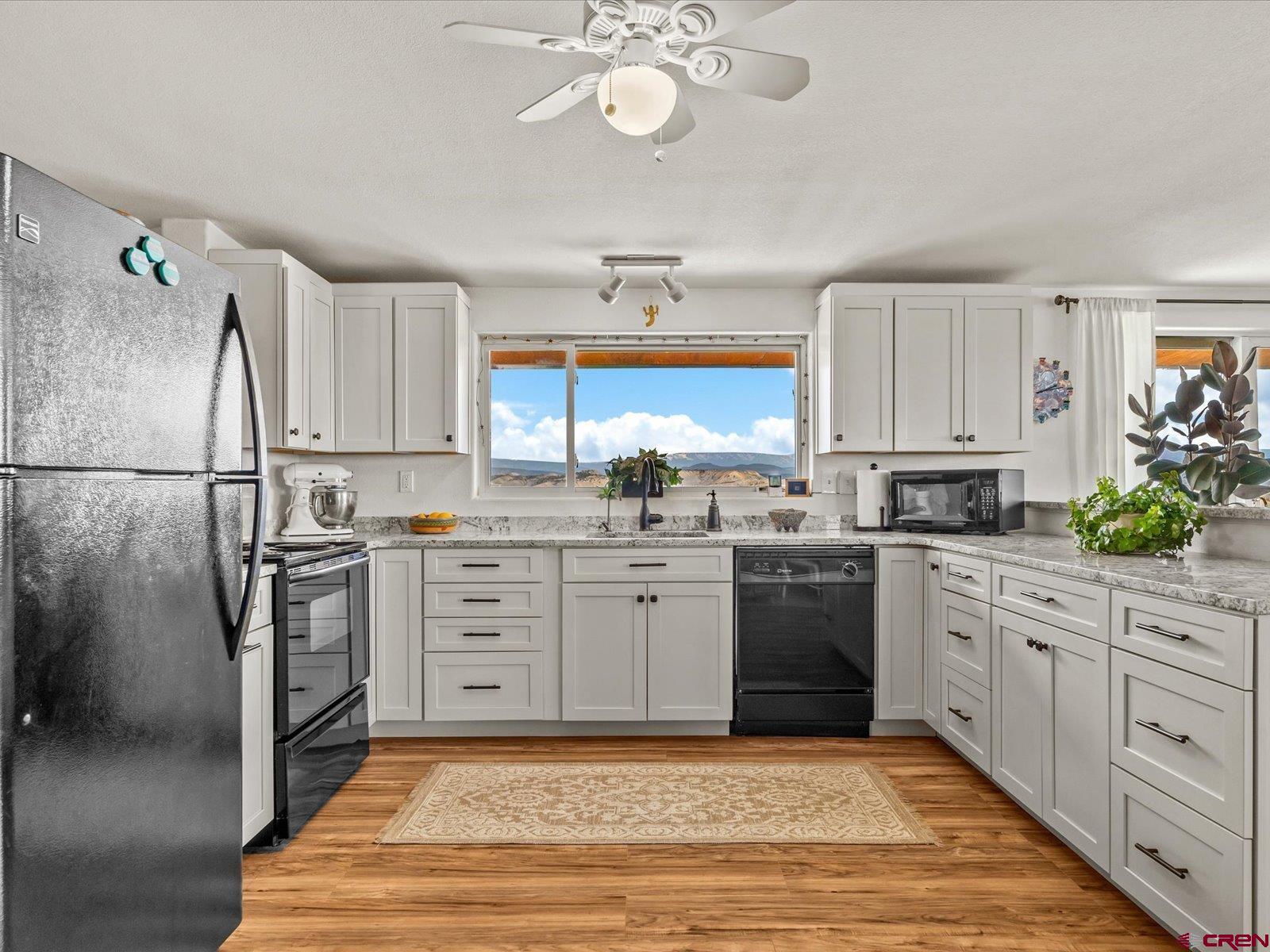 68149 Sunshine Road Montrose, CO 81401 - Photo 6 of 33 a kitchen with white cabinets and stainless steel appliances