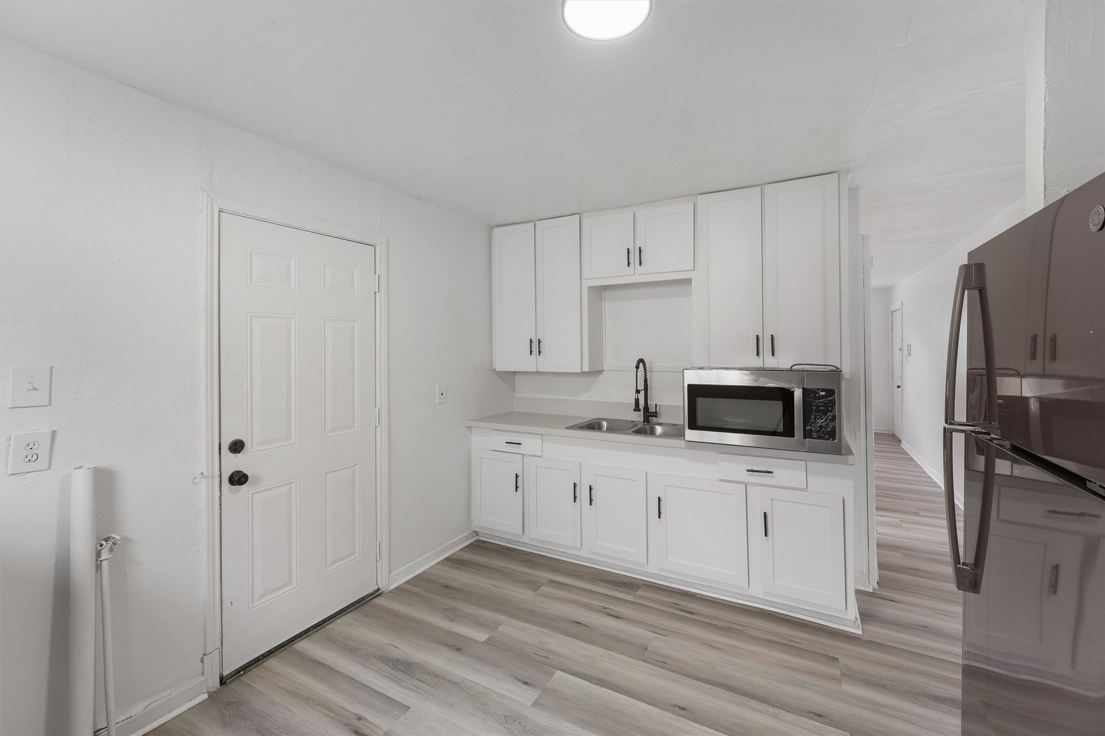 8514 Spaulding Street Houston, TX 77016 - Photo 8 of 19 a kitchen with white cabinets a sink and stainless steel appliances