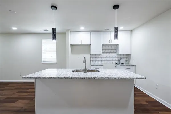 a kitchen with kitchen island granite countertop a sink a window and stainless steel appliances