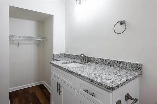 a bathroom with a granite countertop sink and cabinets