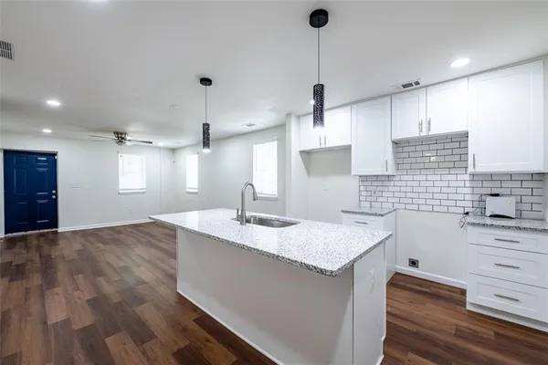 a kitchen with a sink stove and cabinets