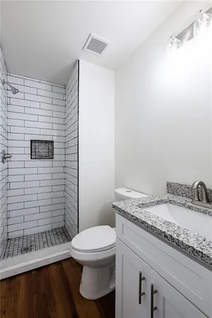 a bathroom with a sink a toilet and shower