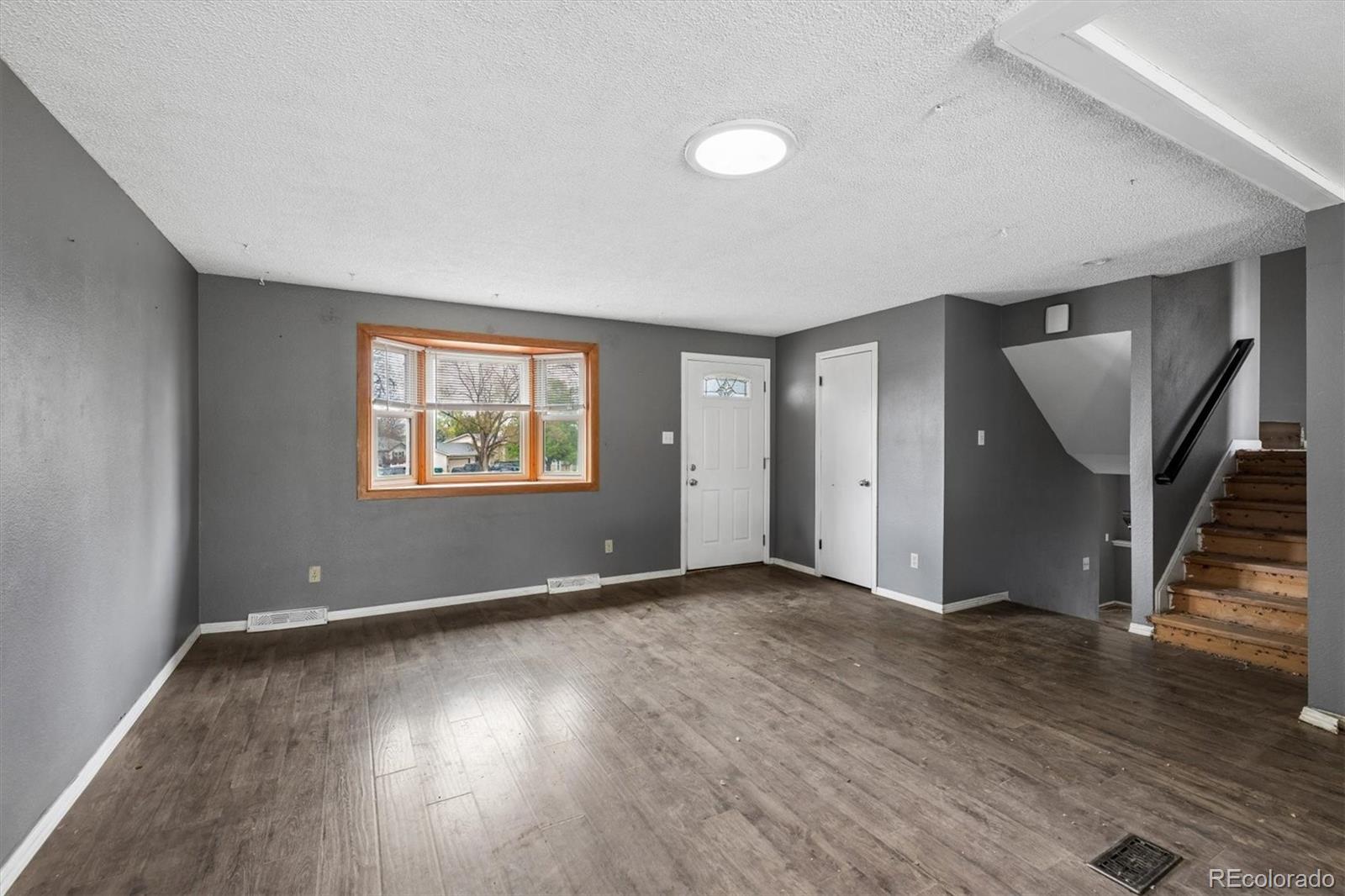 404 Neptune Court Lone Tree, CO 80124 - Photo 2 of 16 an empty room with wooden floor and windows