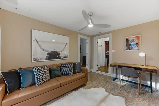 a living room with furniture and a painting on the wall