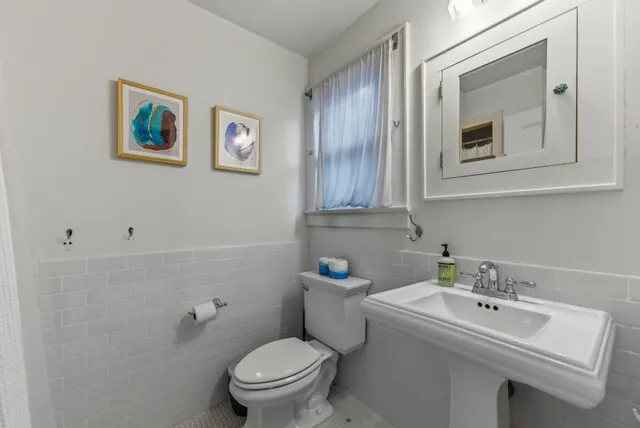 a bathroom with a toilet sink and mirror