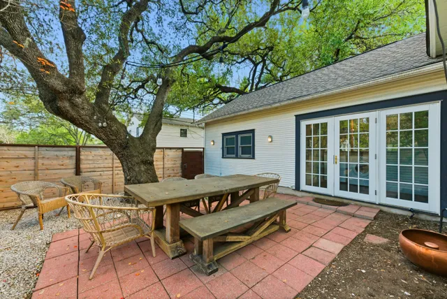 a roof deck with a table and chairs and potted plants