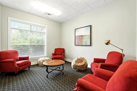 a living room with furniture a rug and a window
