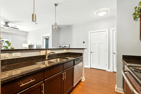 a kitchen with a sink and a wooden floor