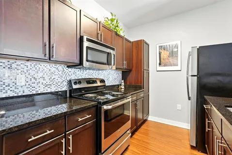 a kitchen with stainless steel appliances granite countertop a stove a microwave and a refrigerator