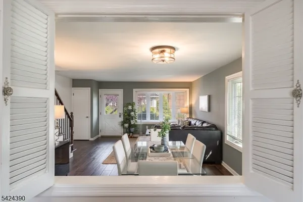 a view of a hallway with wooden floor and a bathroom