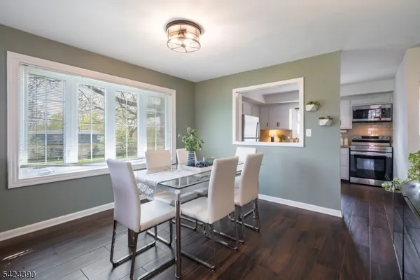 a view of a dining room with furniture a rug and wooden floor