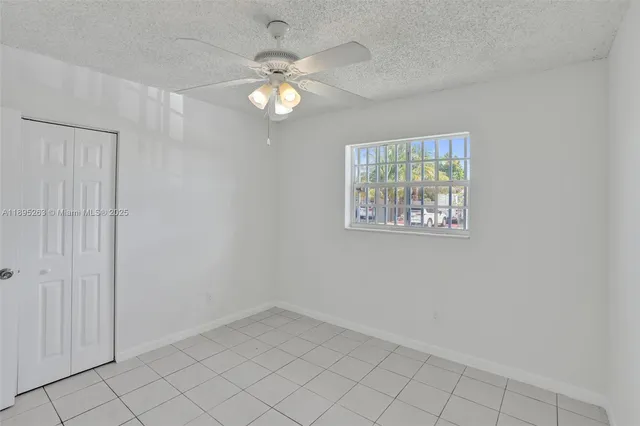 an empty room with a chandelier fan