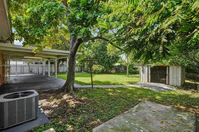 a view of a house with backyard and a tree