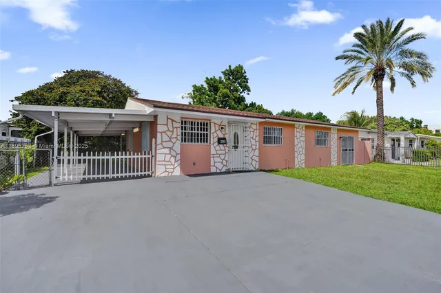 a view of a house with a yard and potted plants