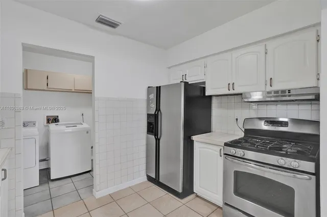 a kitchen with a refrigerator stove and cabinets