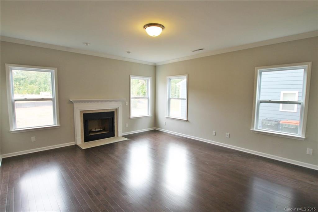 2254 Bluebell Way, Unit 156 Fort Mill, SC 29708 - Photo 5 of 23 an empty room with wooden floor fireplace and windows