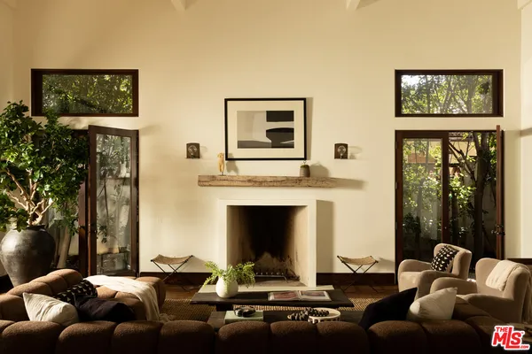 a living room with furniture fireplace and a large window