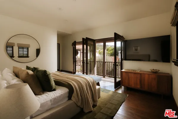 a view of a house with wooden fence and floor to ceiling windows