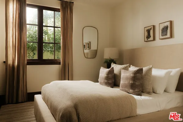 a bedroom with a bed lamp and a large window with outer view