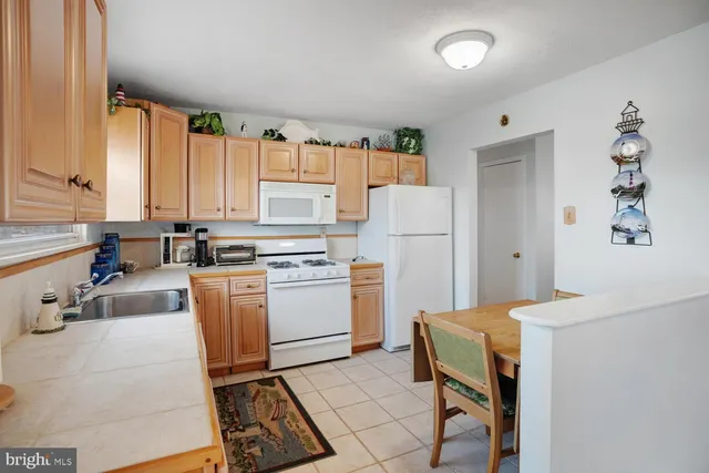 a kitchen with a sink a stove cabinets and a window