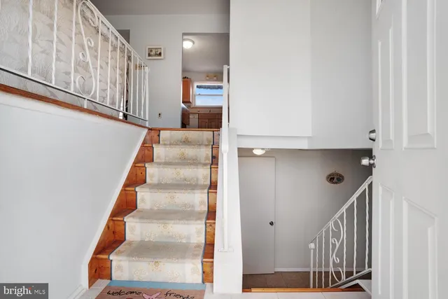 a view of staircase with white walls and railing