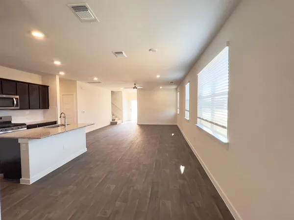 a view of a kitchen with wooden floor and stainless steel appliances
