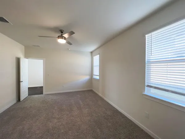an empty room with a window and a ceiling fan