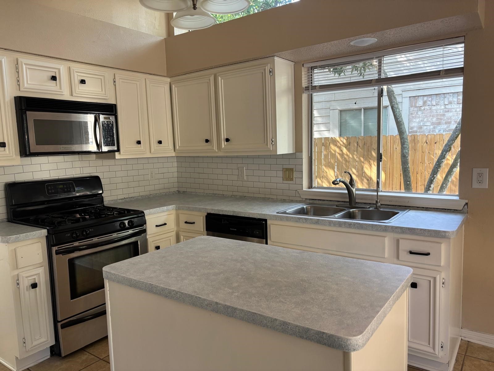 22 South Rain Forest Court Spring, TX 77380 - Photo 7 of 29 a kitchen with granite countertop a stove sink and microwave