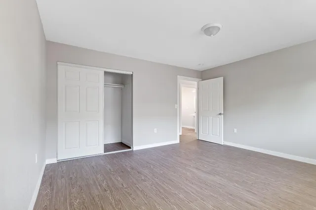 a view of an empty room with wooden floor