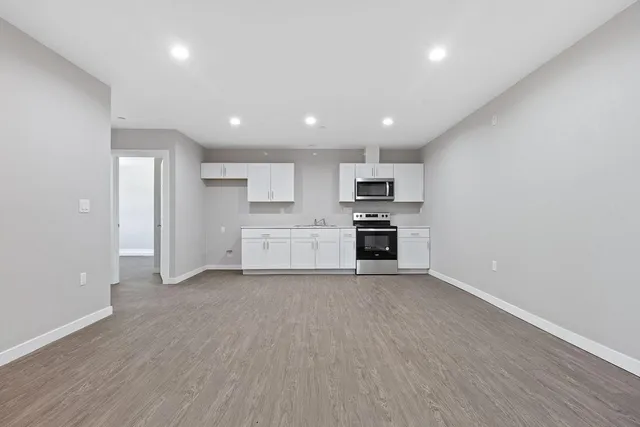 a view of kitchen with stainless steel appliances refrigerator and cabinets
