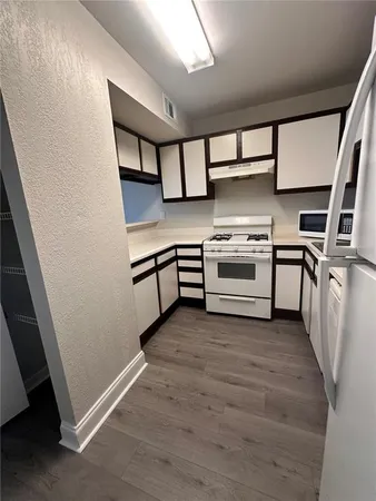 a kitchen with stainless steel appliances a stove a sink and cabinets