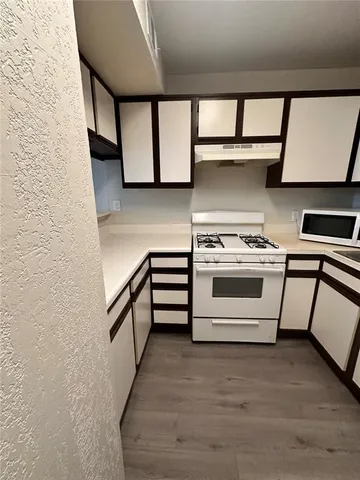 a kitchen with stainless steel appliances granite countertop a stove and a white cabinets