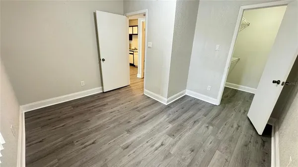 an empty room with wooden floor and entrance