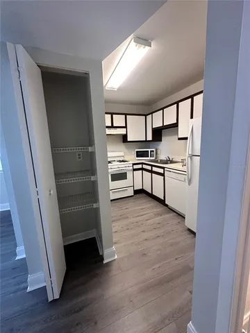 a kitchen with stainless steel appliances a stove and white cabinets