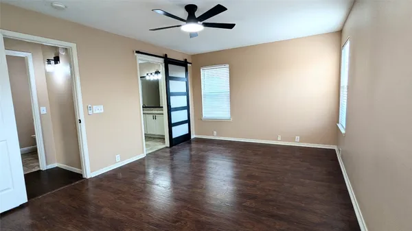 an empty room with wooden floor closet and windows
