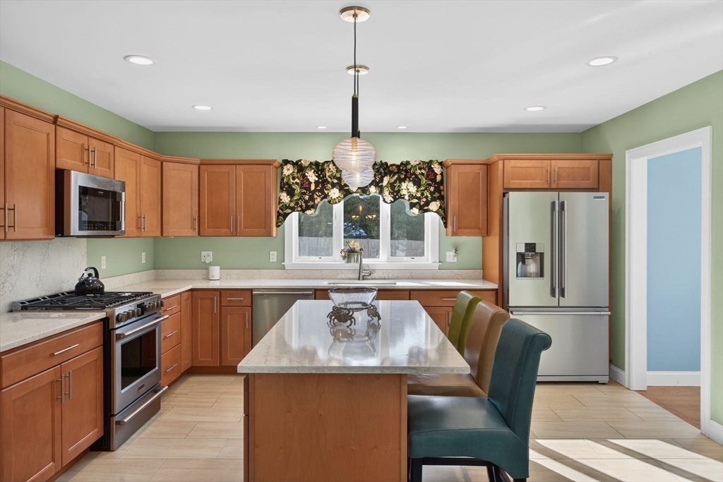 26 Crosswinds Way Falmouth, MA 02536 - Photo 23 of 41 a kitchen with stainless steel appliances granite countertop a stove top oven a sink dishwasher a dining table and chairs with wooden floor