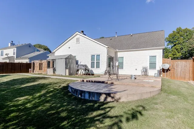 a view of a house with backyard and sitting area