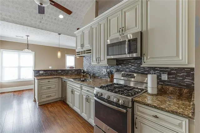 a kitchen with cabinets wooden floor and stainless steel appliances