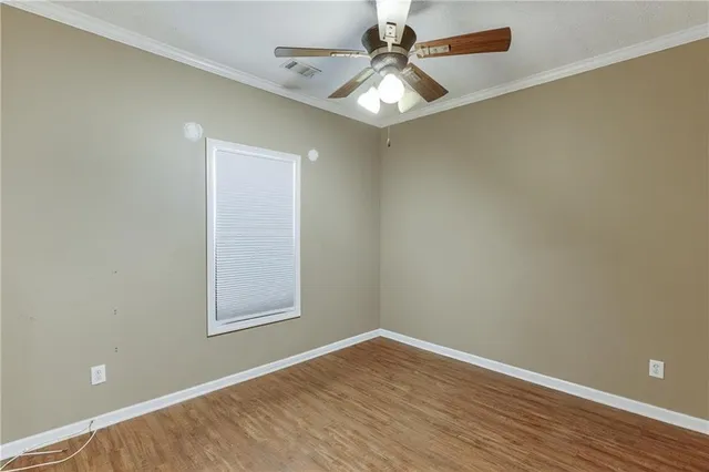 an empty room with a window and wooden floor