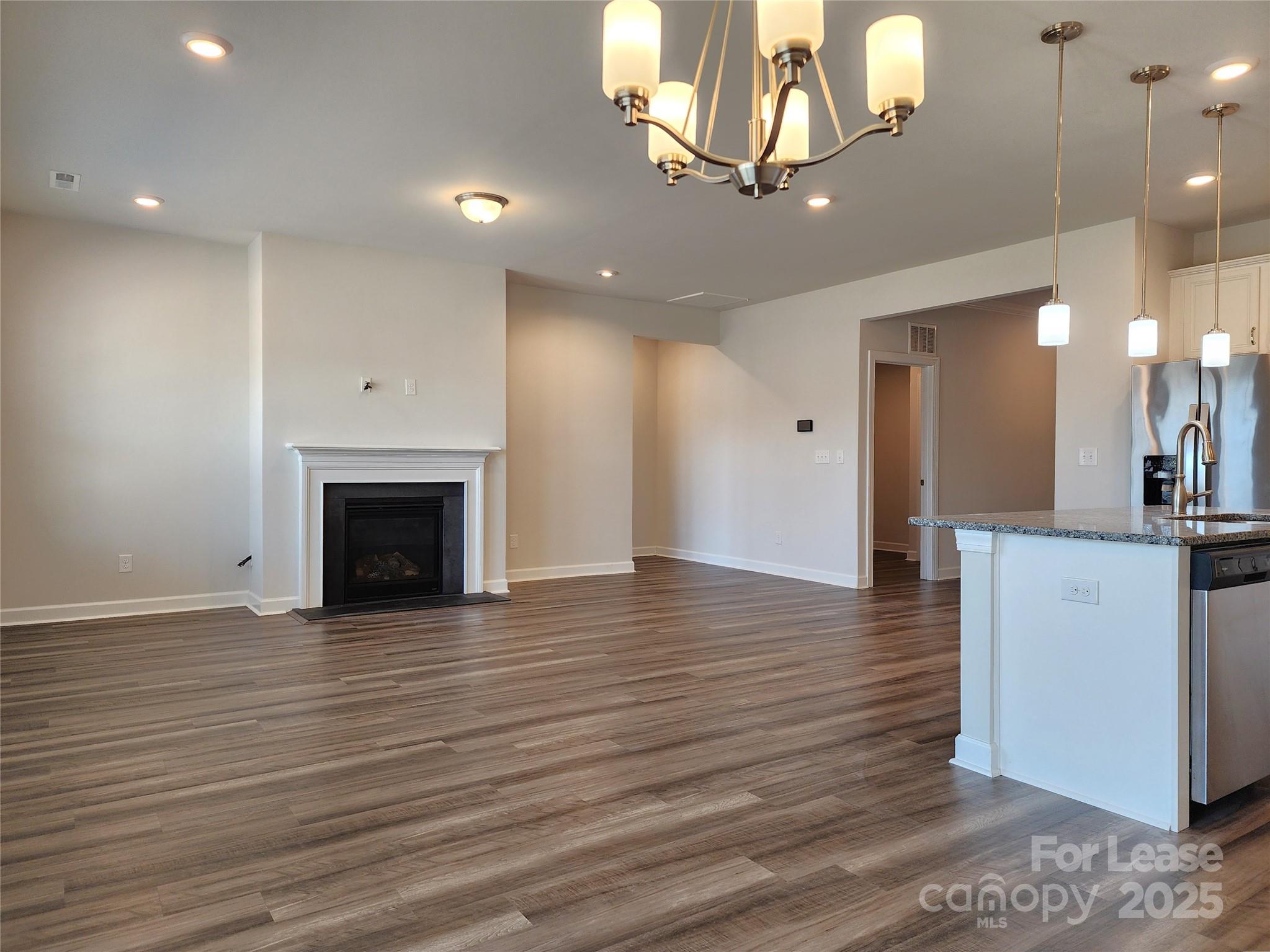 4227 Canopy Creek Drive Denver, NC 28037 - Photo 11 of 33 a view of an empty room with wooden floor and a kitchen view